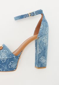 Denim høyhælte sandal med ankelstropp, lys blå farge, teksturert stoff, blomstermønster og chunky hældesign.