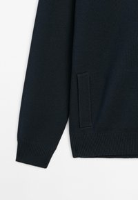 Dark navy-knit sweater featuring a textured pattern, ribbed cuffs, hem, and a side pocket detailed with a thin accent.