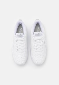 Baskets de sport blanches avec une tige synthétique lisse, un bout perforé, des fermetures à lacets et un logo sur la languette et sur le côté.