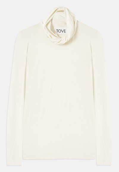 Langarm crèmekleurig shirt met een hangende, buisvormige halslijn. Gemaakt van zachte stof, heeft het een gladde textuur en een label met de tekst "TOVE."