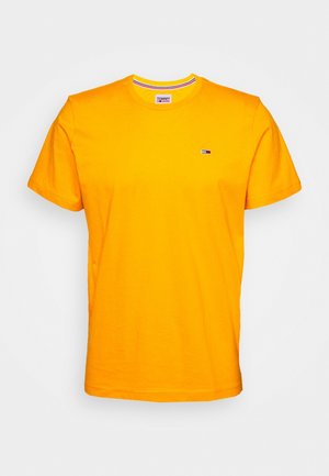 Jasnożółta koszulka z krótkim rękawem wykonana z bawełny. Posiada okrągły dekolt z paskowanym wewnętrznym pasem oraz małe logo na piersi.