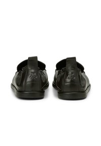 Czarne skórzane buty slip-on z zaokrąglonym noskiem, elastycznymi panelami bocznymi i małą pętelką z tyłu. Logo wytłoczone na pięcie.