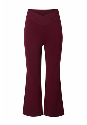 Pantaloni larghi bordeaux con vita incrociata, realizzati in tessuto elasticizzato; texture liscia e aderenti in alto, che si allargano sotto il ginocchio.