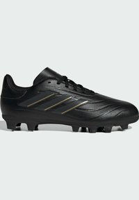 Botín de fútbol negro con un diseño elegante, parte superior de cuero sintético, superficie texturizada y tres rayas doradas decorativas. Suela con tacos para tracción.