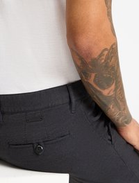 Dunkel strukturierte Hosen mit schlankem Schnitt, ausgestattet mit einer Gesäßtasche mit Knopfverschluss und einem kleinen Markenetikett. Material aus Baumwollgemisch.