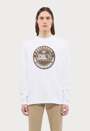 White long-sleeve shirt with textured fabric featuring a round graphic print in brown, stating "København SPRING SUMMER 24 DANMARK."