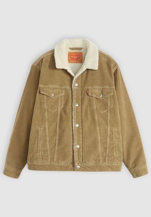 Chaqueta de pana marrón con un collar de borreguito sintético color crema. Presenta dos bolsillos en el pecho, cierre de botones y detalles de costura vertical.