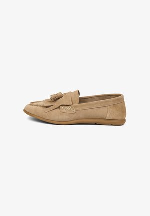 Mocassin en daim beige avec détail à glands, accents cousus et semelle basse en caoutchouc, présenté de profil sur un fond blanc.