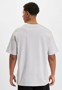 Hvid bomulds t-shirt, afslappet pasform, rund halsudskæring, korte ærmer, glat tekstur, ingen synlige mønstre, ensfarvet bagview, afslappet design.