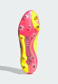 Semelle de crampons de football Predator, avec un design vibrant jaune et rose, composée de six crampons coniques et d'une surface texturée. Détail du logo noir inclus.