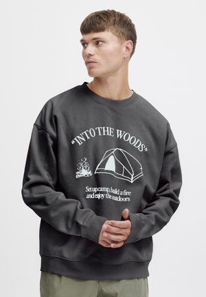 Dark grey sweatshirt with a crew neckline, featuring white graphic text and illustrations of a tent and campfire. Soft, relaxed fit.