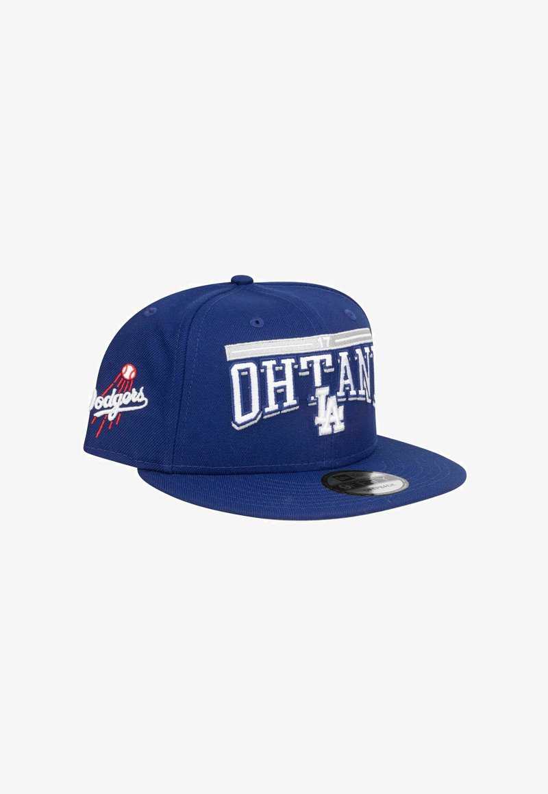 Blaues Baseball-Cap mit flachem Schirm, das "OHTANI" und "LA" in Weiß gestickt hat, sowie ein Dodgers-Logo in Rot und Weiß an der Seite.