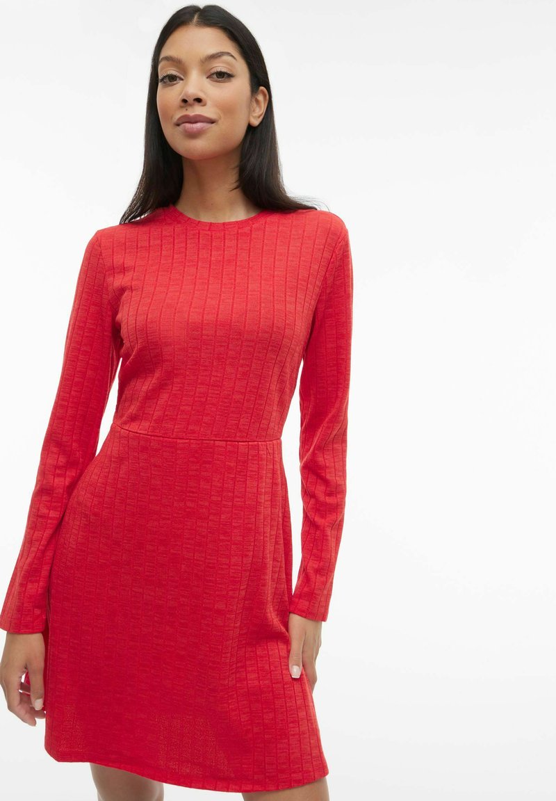 Robe rouge à manches longues avec un motif texturé, corsage ajusté et jupe évasée, réalisée en tissu doux avec un col rond.