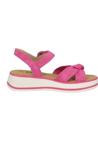 Sandalo in suede rosa con design a strappo incrociato, cinturino elastico alla caviglia e suola platform bianca con una linea rosa.