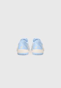 Light blue athletic shoes with mesh fabric, textured patterns, and a white sole. Features a yellow accent logo on the heel.
