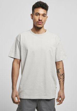 Light gray cotton t-shirt with short sleeves, a round neckline, and a relaxed fit. Features stitching details and a small logo tag at the hem.