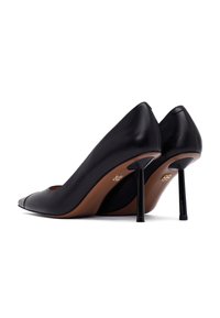 Tacchi alti in pelle nera con punta affusolata, sottile tacco a spillo nero e suola in pelle color cuoio; design minimalista senza ulteriori accenti.
