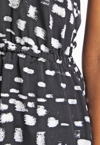 Black fabric with white brushstroke pattern, featuring an elastic waistband, gathered texture, and lightweight drape.