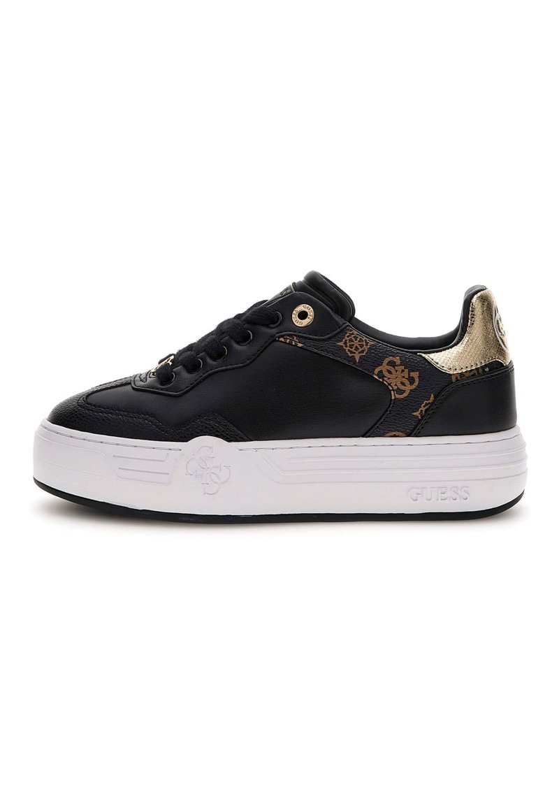 Black sneaker with leather upper, gold accents, and raised white rubber sole; features logo and intricate pattern on side panel.