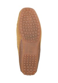 Schuhsohle aus braunem Gummi-Material, mit einem strukturierten Muster aus Quadraten und Kreisen für besseren Halt. Die Seite zeigt ein Obermaterial aus beige Niederleder.