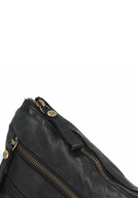Borsa in pelle nera con due scomparti zip visibili, dettagli in hardware dorato e una finitura testurizzata. Forma triangolare compatta nella parte superiore.