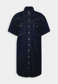 Mörk denimklänning med spetsig krage, korta ärmar, två bröstfickor, knappstängning fram och kontrasterande sömmar.