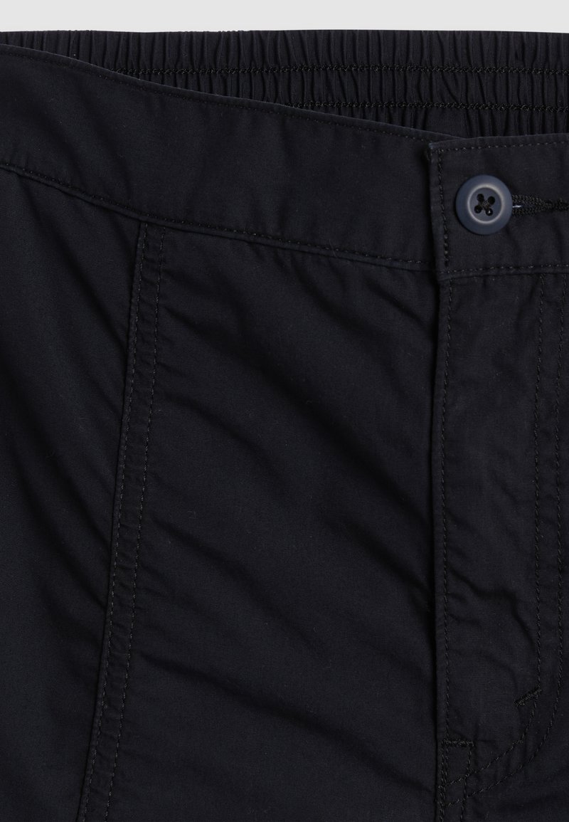 Schwarze Shorts mit elastischem Bund, einem Knopfverschluss, strukturiertem Stoff und sichtbaren Nähten entlang der Säume.