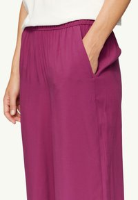 Magenta wijde broek met een elastische tailleband, met zijzakken en een gladde, lichte textuur. Geen patronen of zichtbare accessoires.