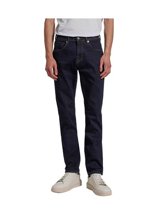 Dark blue denim jeans with a straight leg fit, five-pocket design, and orange stitching details, paired with light beige sneakers.