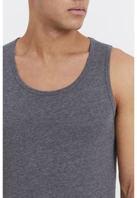 Graues, ärmelloses Tanktop aus einem weichen, strukturierten Material mit rundem Ausschnitt und sauberer Nahtverarbeitung, eng anliegend im Brust- und Armbereich.