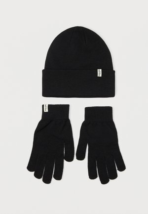 Black knit beanie, featuring a folded cuff. Paired with black knit gloves, each with five finger design and ribbed wrist cuffs.