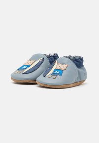 Weiche blaue Leder-Babyschuhe mit einem gerüschten Knöchel, versehen mit einem Katzenmotiv und einem Surfbrett. Wildledersohlen für Grip und Komfort.