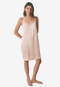 Lyserød satin natkjole med justerbare stropper, blondedetalje og en løs, lige pasform. Stoffet fremstår glat og blødt at røre ved.