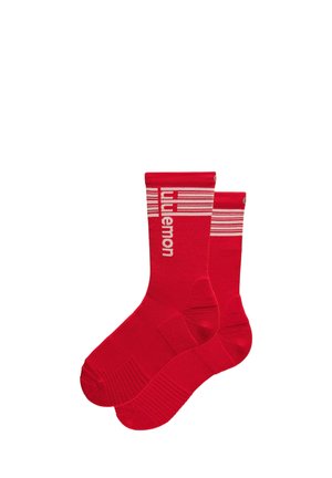 Paire de chaussettes de sport rouges avec des rayures horizontales blanches et le texte "lululemon" près du bord supérieur, conçues pour le sport ou un usage décontracté.