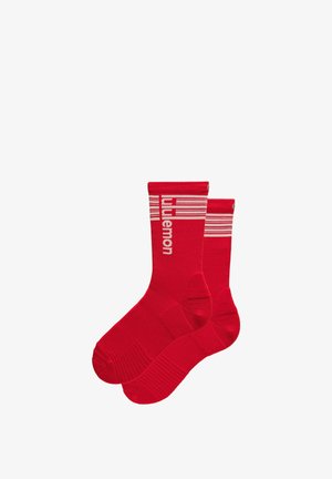 Para czerwonych sportowych skarpetek za kostkę z białymi poziomymi paskami i napisem "lululemon" przy górnej krawędzi, zaprojektowanych do uprawiania sportu lub noszenia na co dzień.