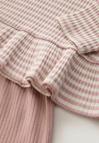 Top din bumbac cu un model în carouri roz și crem, tiv ondulat și textură côtorel. Mâneci scurte cu un detaliu subtil de mansetă.