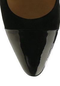 Fekete hegyes orrú női cipő fényes lakkbőr orrkappal és matt felső anyaggal.