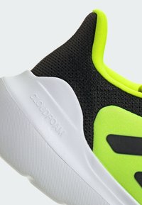 Black and neon green athletic shoe with a mesh upper, cushioned white Cloudfoam sole, and distinctive black accents on the sides.