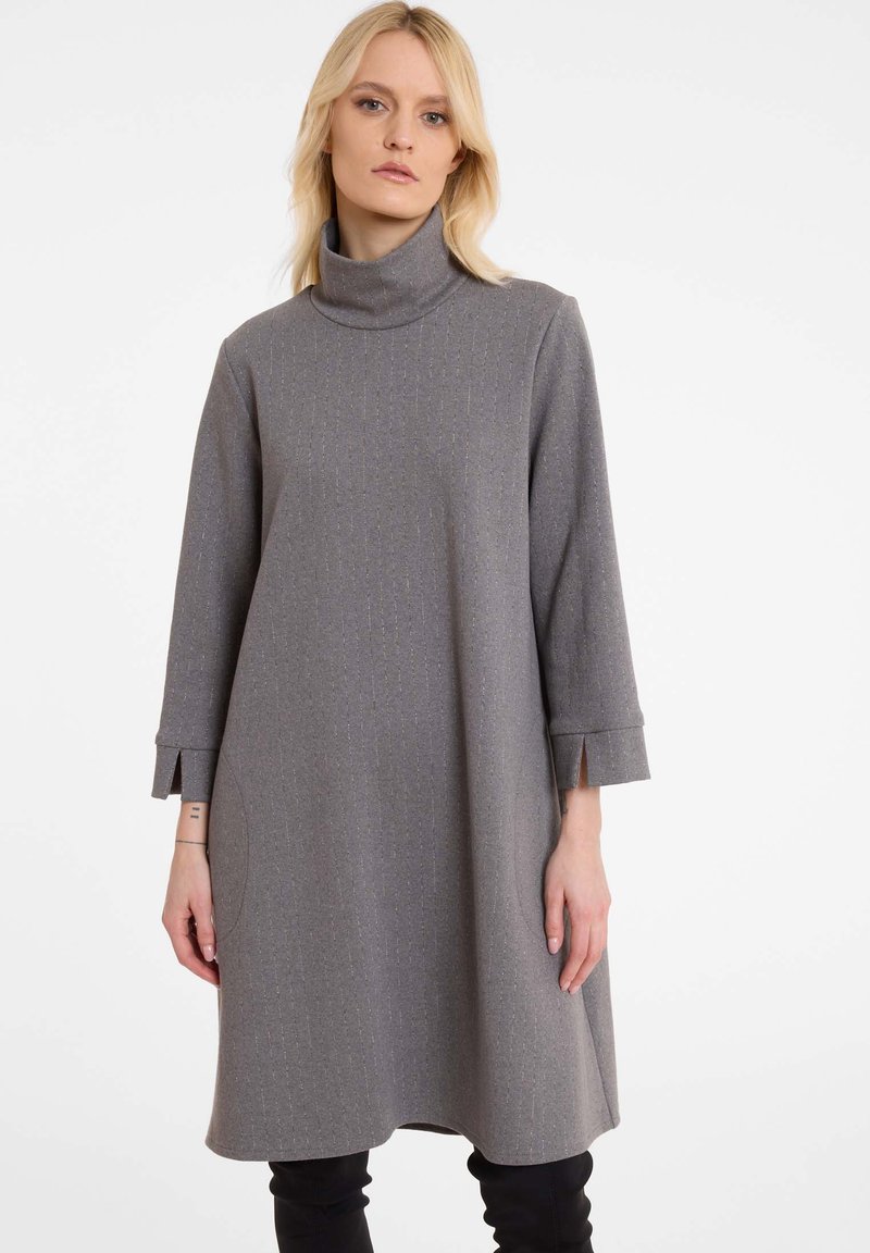 Graues Rollkragenkleid mit lockerer Passform, das ein strukturiertes Muster aufweist, dreiviertellange Ärmel mit Schlitzen und seitlichen Taschen.