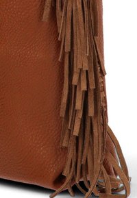 Bolso de mano de cuero marrón con un acabado texturizado, que presenta flecos largos y cortados de manera uniforme a lo largo de un lado para añadir detalle.