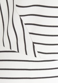 Tissu blanc avec de fines rayures horizontales noires, certaines rayures légèrement courbées en raison des plis dans le matériau.