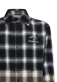 Camicia a quadri bianca e nera con colletto. Presenta il testo ricamato "PROPERTY OF RICHMOND X" e un giallo a contrasto all'orlo.