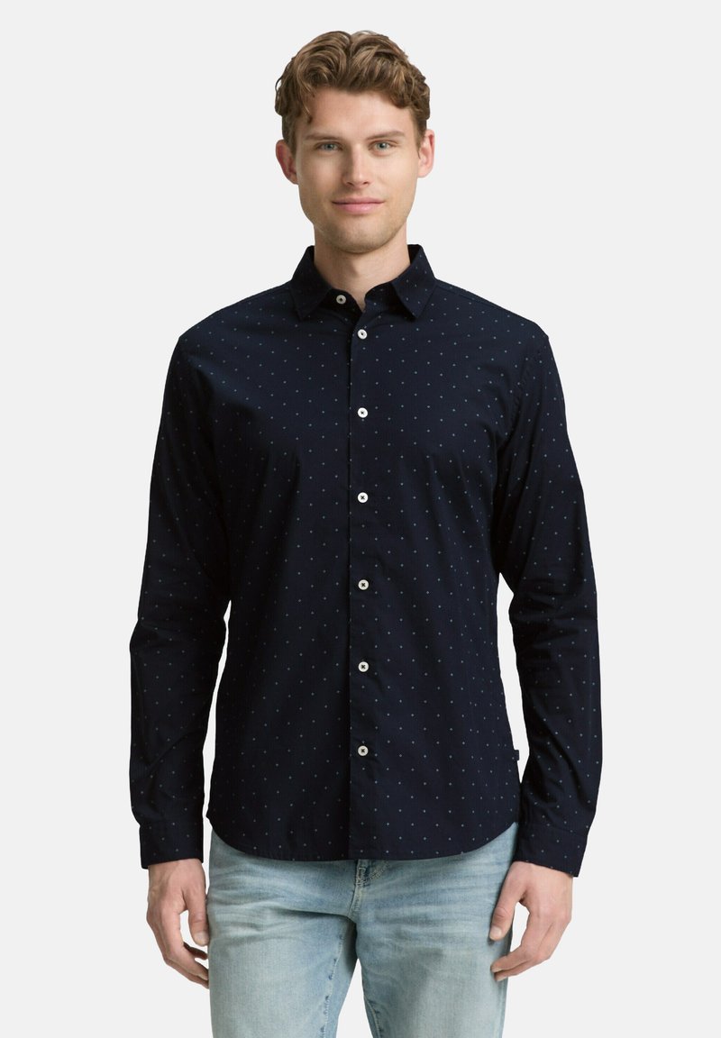 Marineblaues Hemd mit Knöpfen, kleinen hellblauen Pünktchen, langen Ärmeln und klassischem Kragen. Baumwollstoff mit glatter Textur.