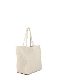 Beige tote-väska med upphöjd text, dubbla handtag och en strukturerad form. Slät textur och minimalistisk design utan ytterligare accenter.