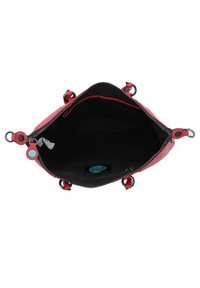 Borsa in pelle rossa con chiusura a zip, interno in tessuto nero, accento circolare blu e hardware in argento. Vista aperta che mostra ampio spazio.