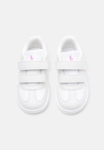Zapatillas deportivas blancas para niños con dos cierres de velcro y logo bordado en rosa en la lengüeta y los lados, vistas desde arriba sobre un fondo claro.