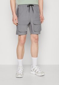 Šedé cargo šortky s elastickým pasem a šňůrkou, dvěma velkými předními kapsami a boční kapsou na zip.