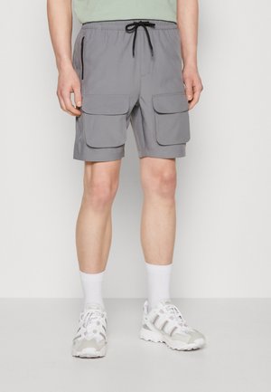 Shorts cargo gris avec une taille élastique et un cordon de serrage, deux grandes poches avant et une poche zippée sur le côté.