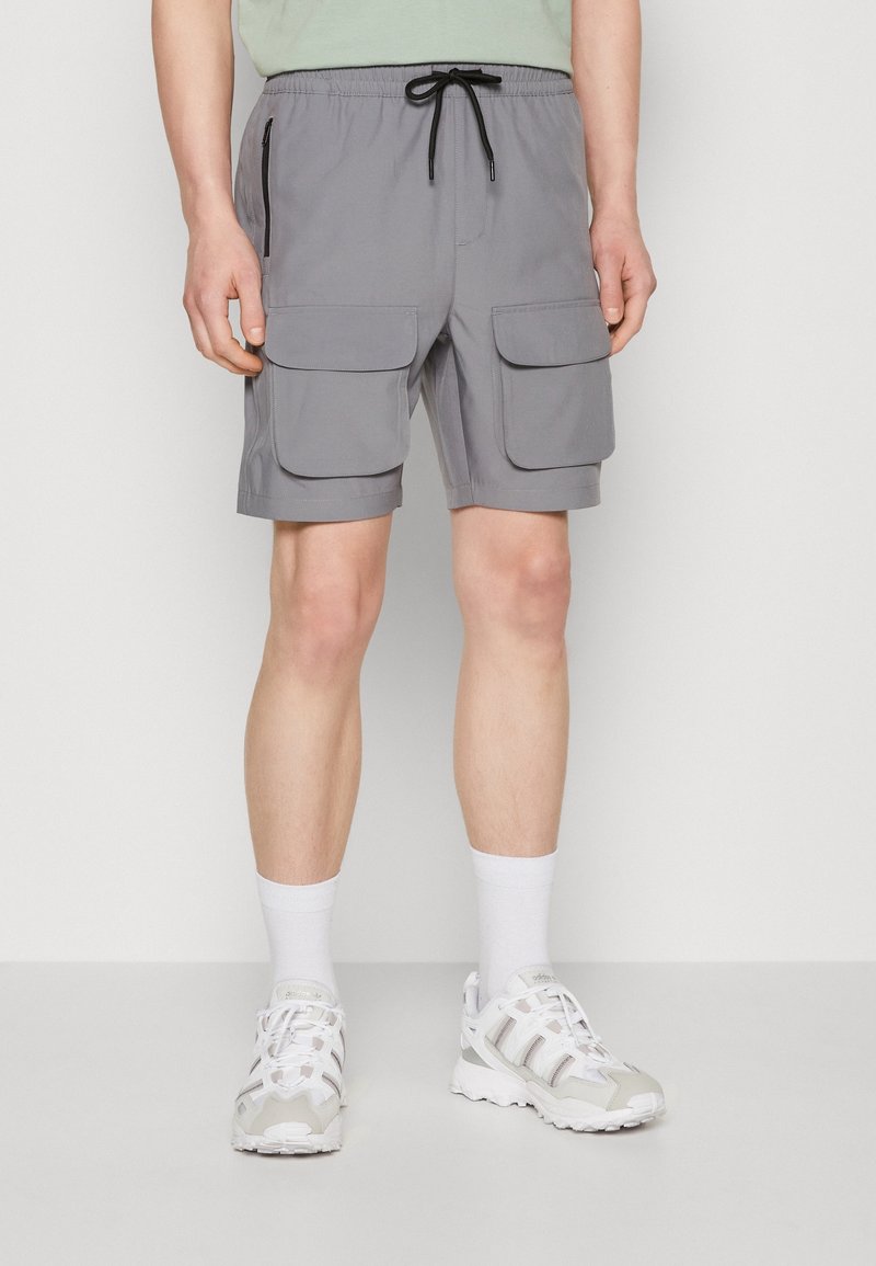 Šedé cargo šortky s elastickým pasem a šňůrkou, dvěma velkými předními kapsami a boční kapsou na zip.