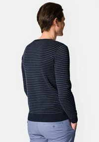 Sweter w paski w kolorze marynarskim, wykonany z miękkiego teksturowanego materiału, z jasnoszarymi poziomymi liniami i ściągaczem na dole. Widok z tyłu z okrągłym dekoltem.